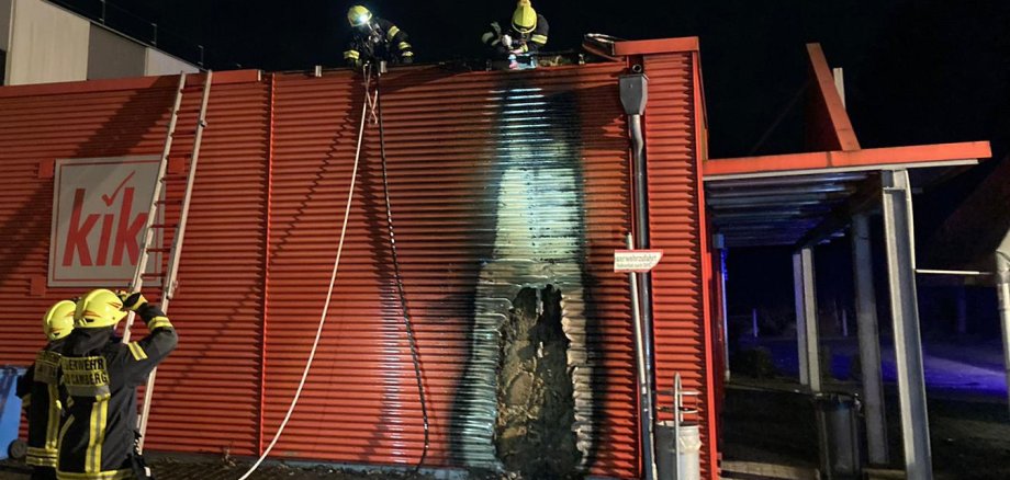 Die Einsatzkräfte löschen die Fassade und kontrollieren, ob sich das Feuer hinter dem Blech weiter gefressen hat.