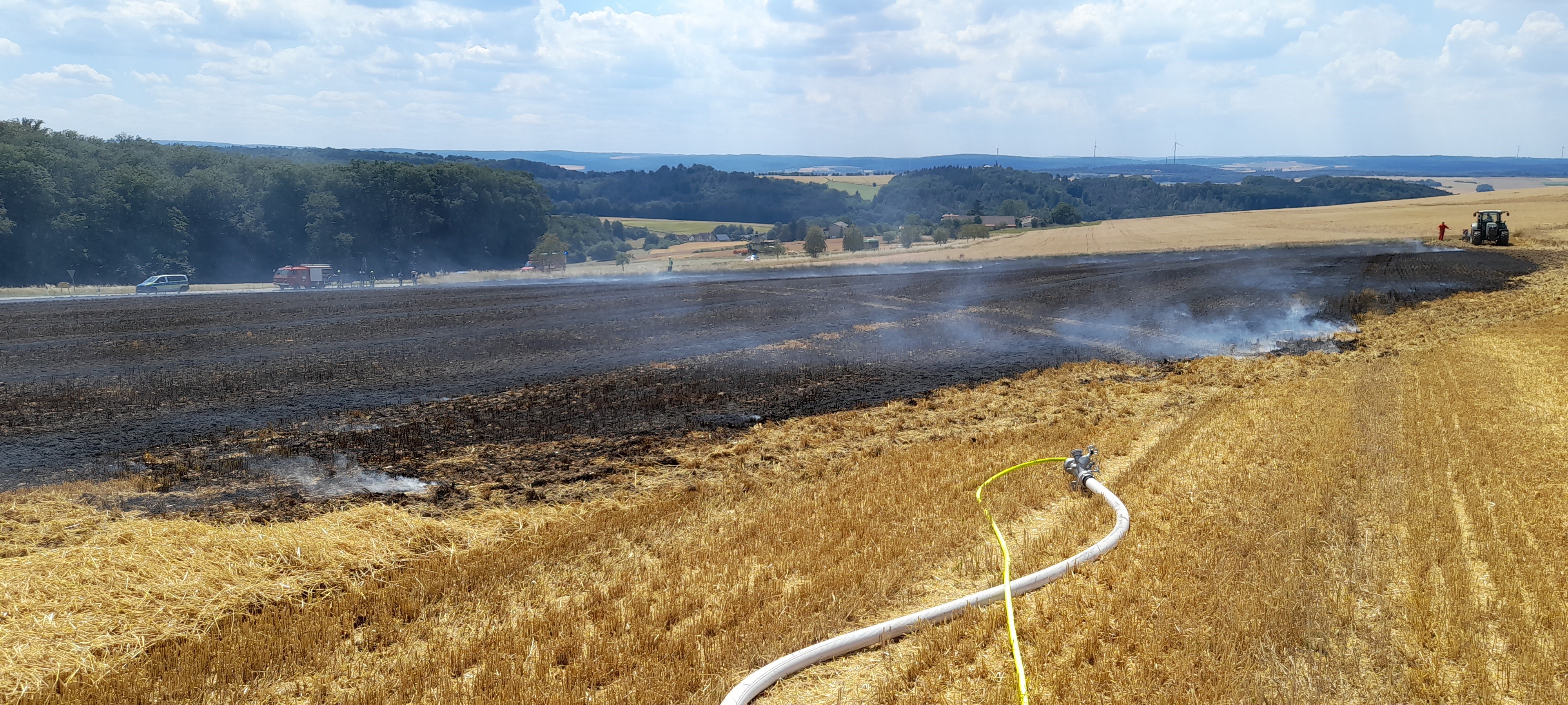 Einsatzkraft der Feuerwehr mit Atemschutzmaskeliegenden Baum