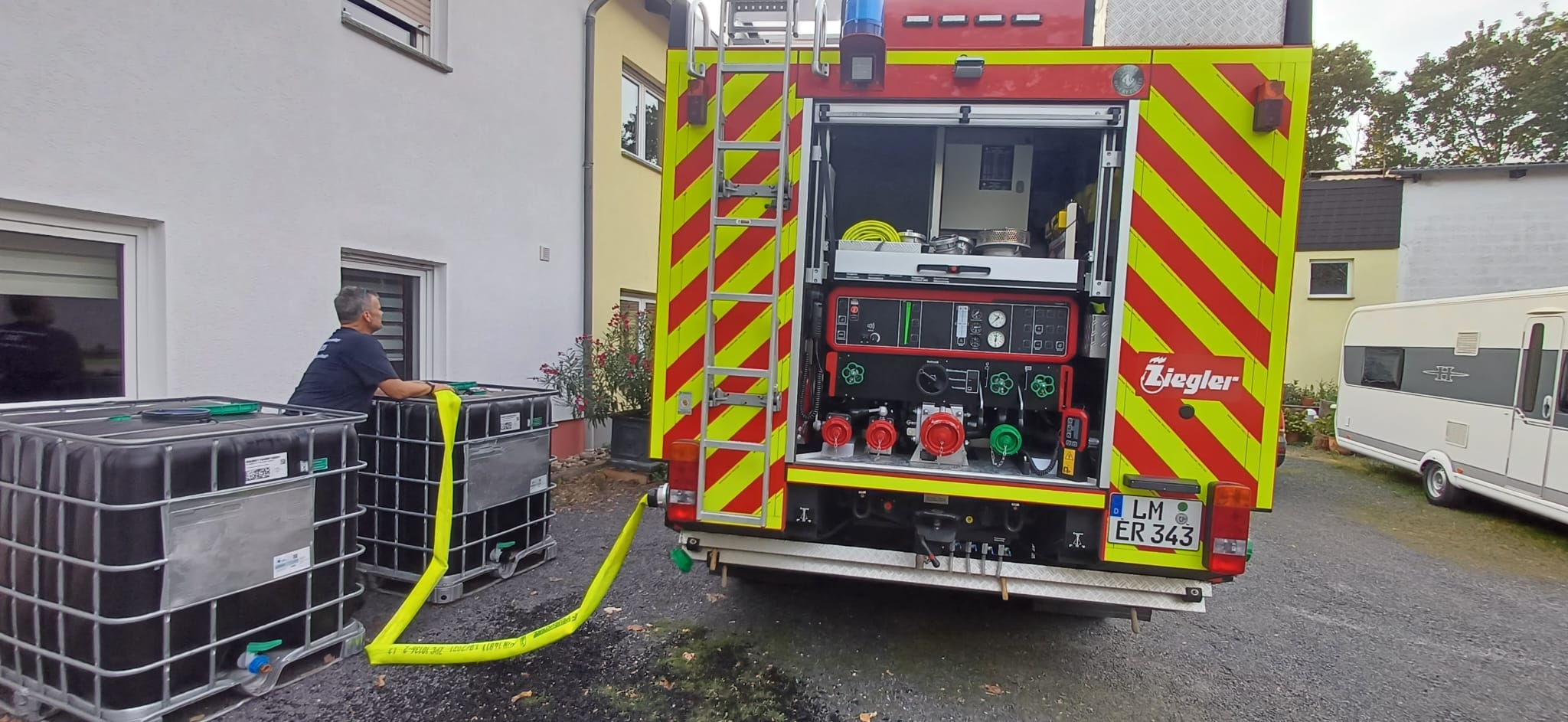 Einsatzkraft der Feuerwehr mit Atemschutzmaskeliegenden Baum