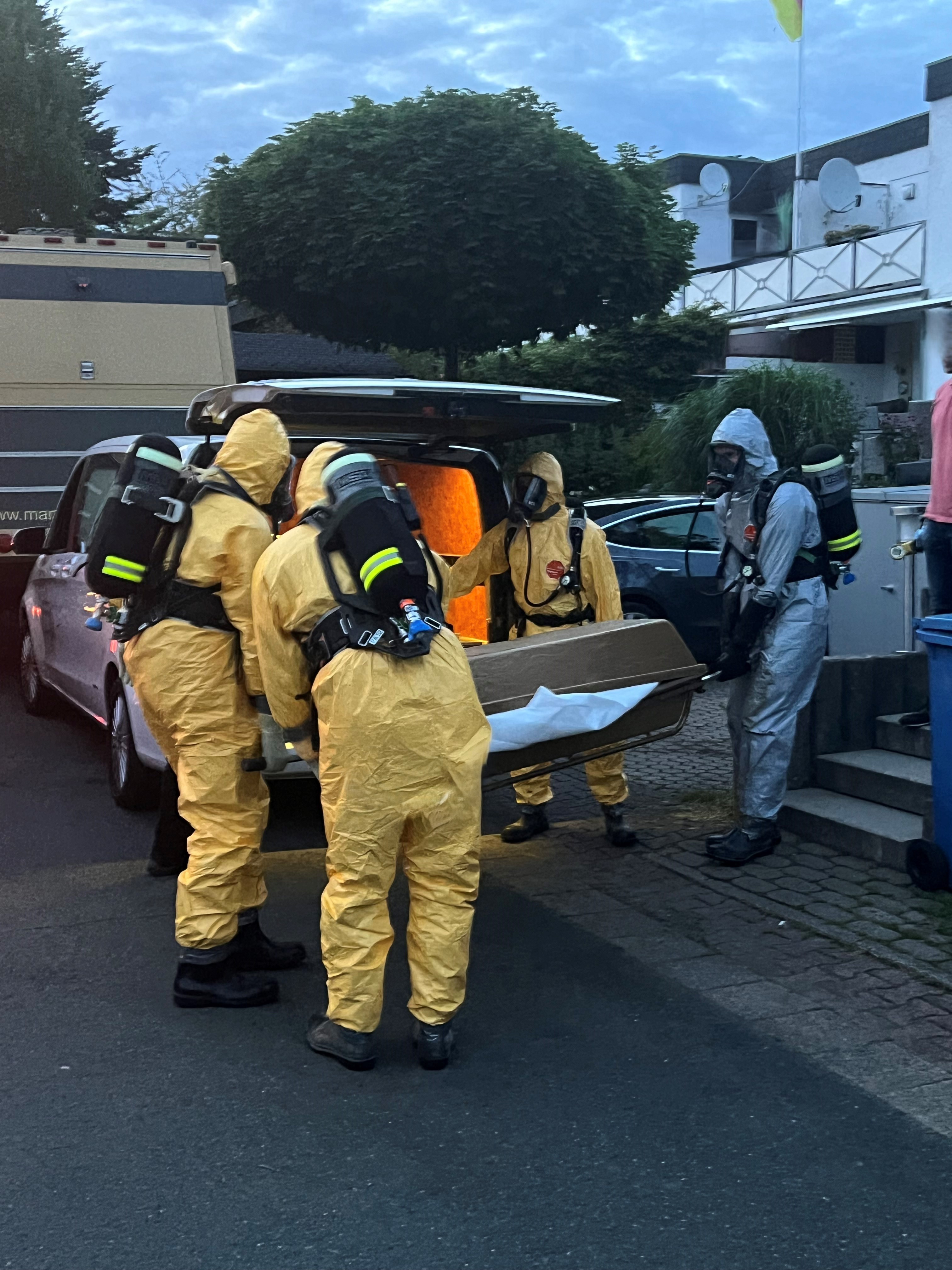 Einsatzkraft der Feuerwehr mit Atemschutzmaskeliegenden Baum